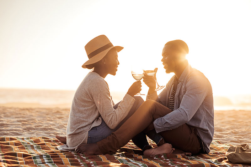 couple enjoying sunset cocktails on private beach
